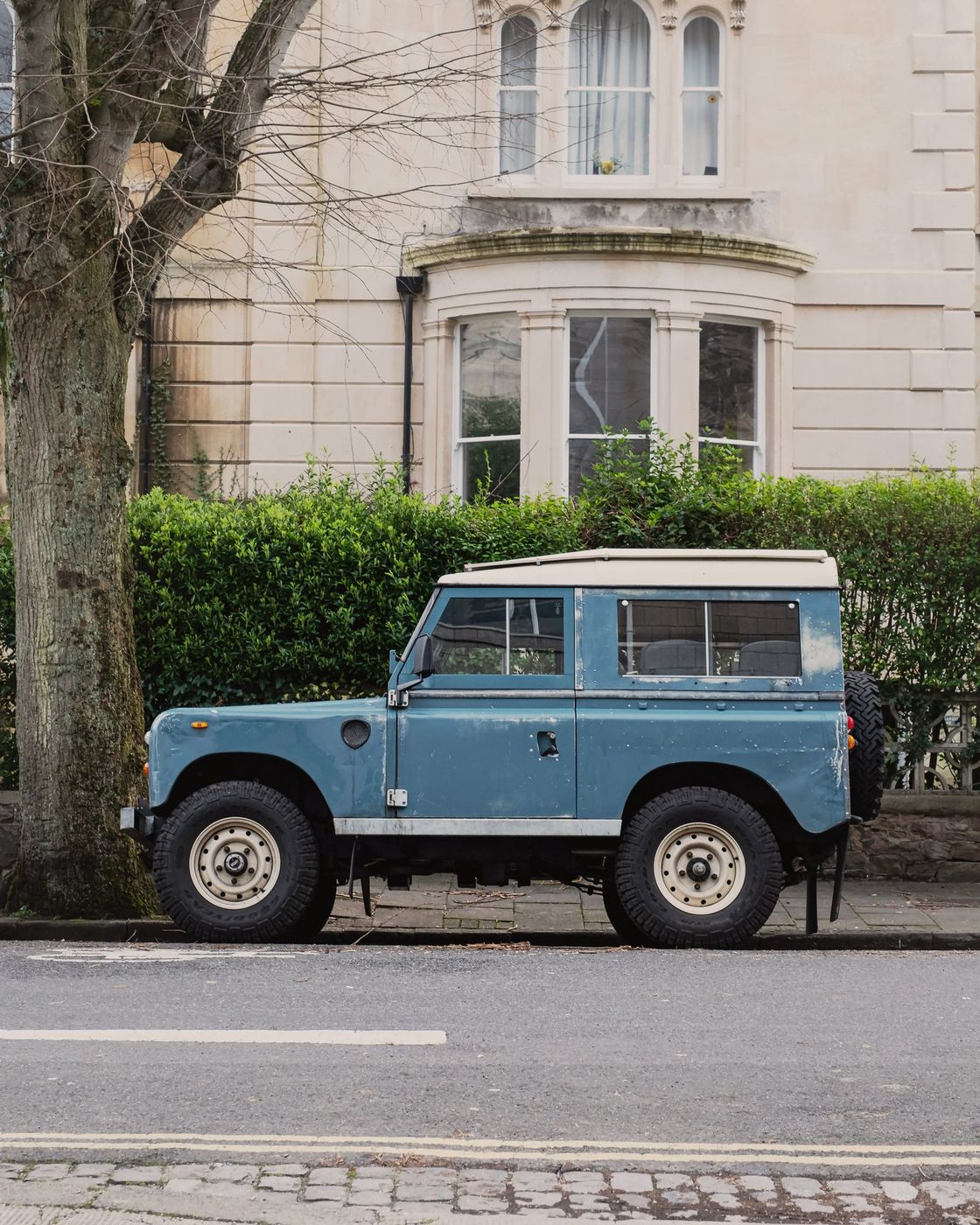 A Series Land Rover parked on a quiet residential street.